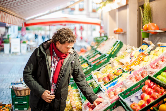 	Junger mann beim einkaufen am Gemüse und Obststand 