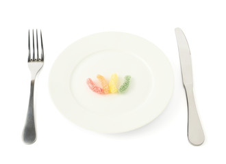 Few colorful candies in a plate isolated