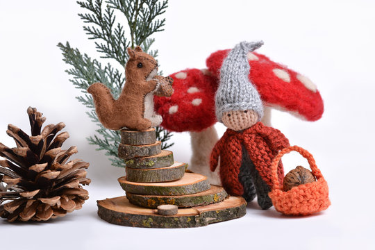 Studio creation of handmade toys, woolly dwarf  in a forest with a squirrel and big mushrooms