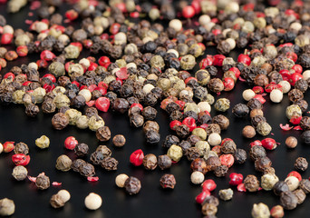 Red, black, green and white peppercorns