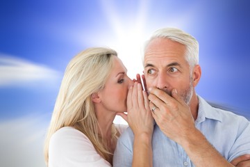 Composite image of woman whispering a secret to husband