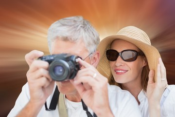 Composite image of vacationing couple taking photo