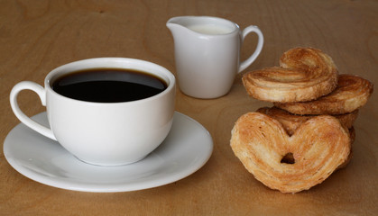Coffee cup, the milk jug and cookies