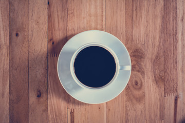 Coffee cup on wooden table (top view)-vintage style color effect