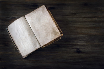 Old open book without  text on a wooden table
