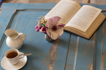 A tea cup and creamer on old wooden table. Top view.