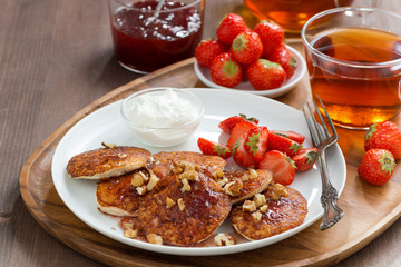 Pancakes with fresh strawberries and cream, jam and tea
