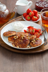 Pancakes with fresh strawberries and cream, jam and tea