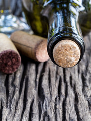 Fototapeta na wymiar Bottle of wine and corks on wooden table. - Macro shot with sele