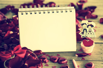 Naklejka na ściany i meble valentines day note among Rose Petals on wooden table, retro fil