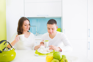 Young beautiful couple eating on kitchen