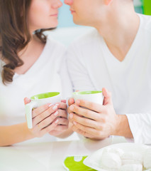 Obraz na płótnie Canvas Young beautiful couple drinking tea on kitchen