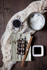 hosomaki sushi on plate with soy sauce and bowl of rice