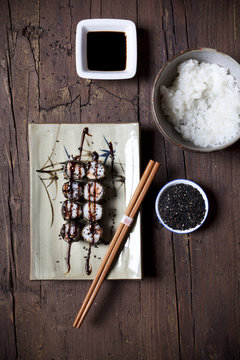overhead shot of hosomaki sushi on plate with soy sauce
