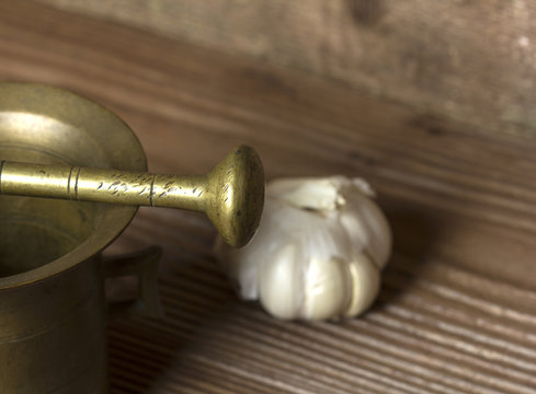 Mortar and garlic on wooden background