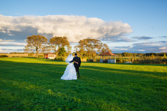 Bride and groom walking on the field