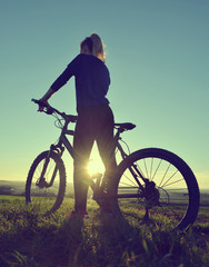 Fototapeta premium Girl on a bicycle in the sunset