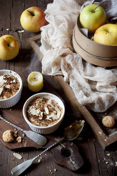 two portions of apple crumble with almonds on wooden table
