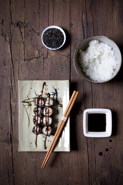 overhead shot of hosomaki sushi on plate with soy sauce and rice