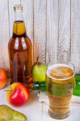 Glass and bottles of cider with fruits