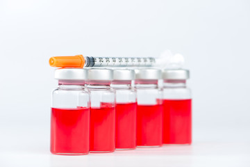 row of injection vials and disposable syringe