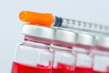 Closed up disposable syringe on injection vials
