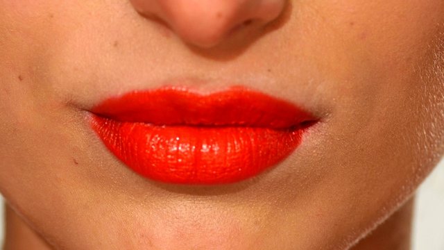 Plump sensual woman`s red lips biting, close up