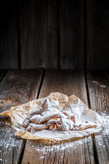 Angel wings with powdered sugar on baking paper - obrazy, fototapety, plakaty