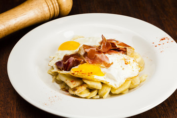 Eggs, potatoes and serrano ham. Huevos rotos.