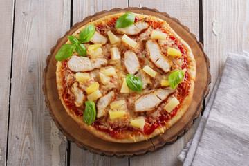 Pizza with cheese and pineapple chicken on board