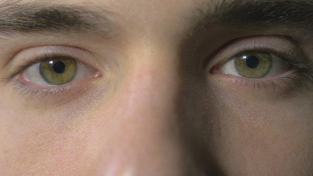 Close-up of a young man eyes opening and blinking