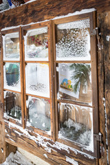 old window with wooden frame covered by snow