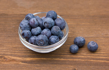 Glass bowl with blueberries on wooden table