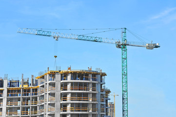 Crane and building construction site against blue sky