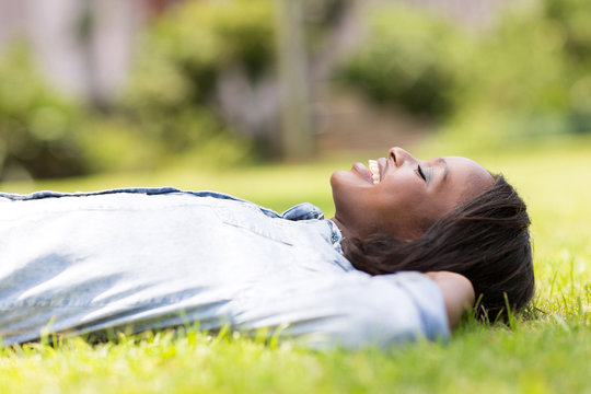 african american woman lying on grass