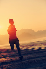 young woman running on sunrise beach