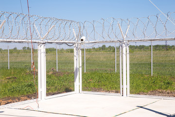 Camcorder and barbed wire on angle fence