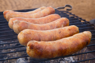 fry sausages on  grill side view