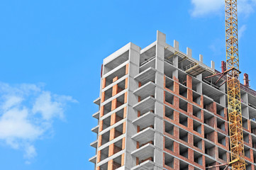 Fototapeta premium Crane and building construction site against blue sky