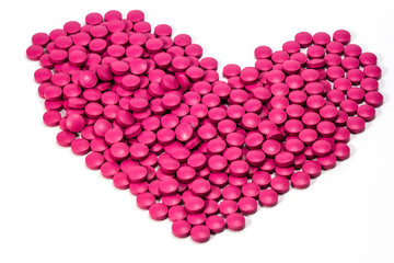 Heart shaped pill on white background