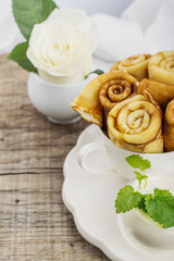 Thin golden pancakes hot rolled tubes in a white cup