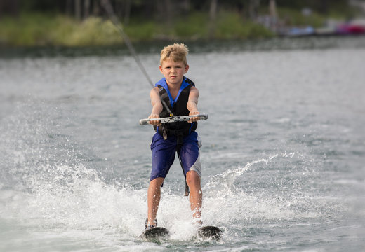 Blonde Boy learning to waterski on a lake
