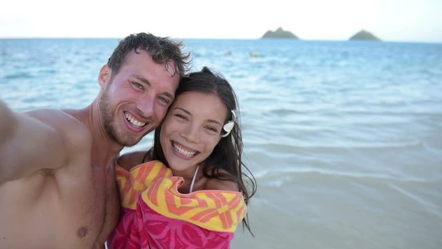Romantic couple taking selfie photograph on beach