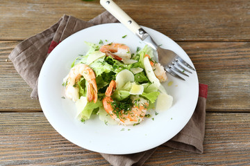 Salad with shrimps, lettuce and parmesan on a plate