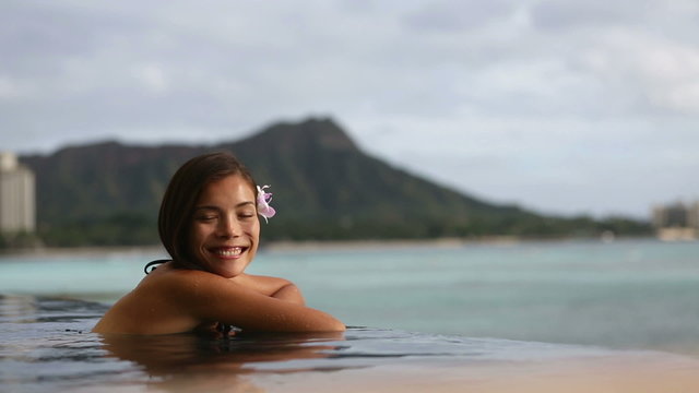 Vacation woman swimming at infinity pool on Hawaii
