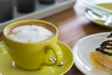 Hot coffee in the yellow Cup whit Bakery