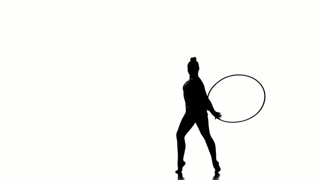 woman exercising Rhythmic Gymnastics hula hoop  in silhouette