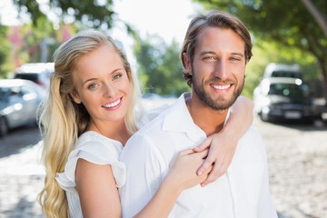 Fototapeta premium Attractive couple hugging each other and smiling at camera