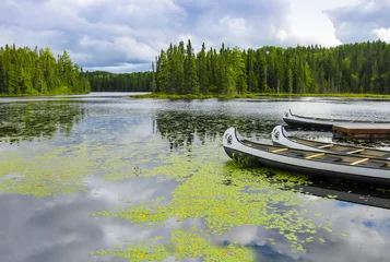 Fototapeten Canoes floating on a peaceful lake, Quebec, Canada © SimoneGilioli