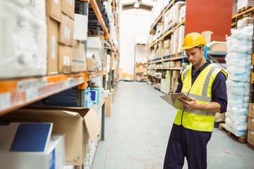 Focused warehouse worker with clipboard